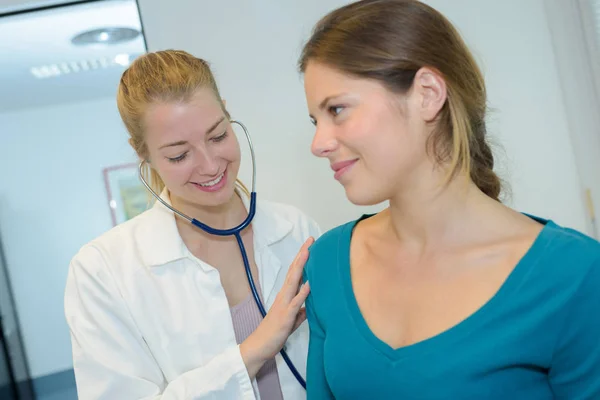 Doctora comprobando hermosa paciente — Foto de Stock