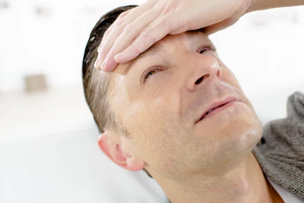 Больной человек с головной болью на диване — стоковое фото
