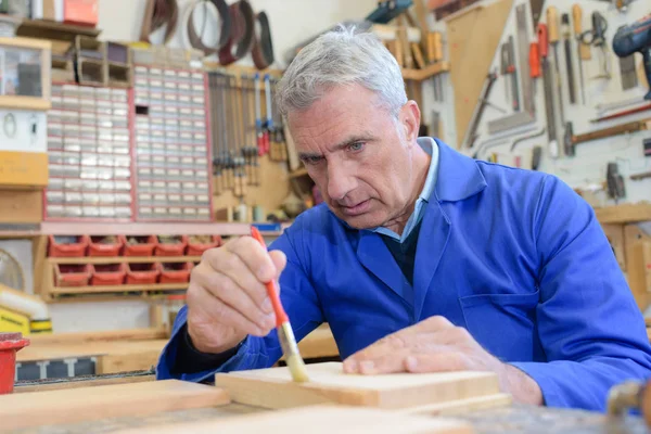 Senior werken in werkplaats lakken hout — Stockfoto