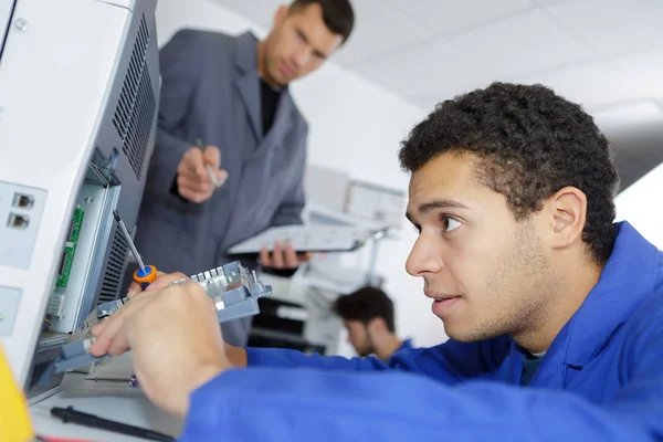Jeune technicien assis près du copieur — Photo