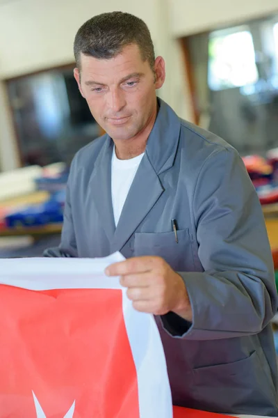 Hombre sosteniendo material rojo con estrella blanca — Foto de Stock
