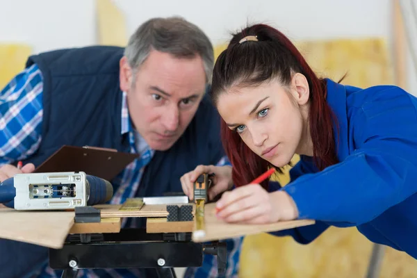 Unga kvinnliga snickeri lärling mäta plywood — Stockfoto