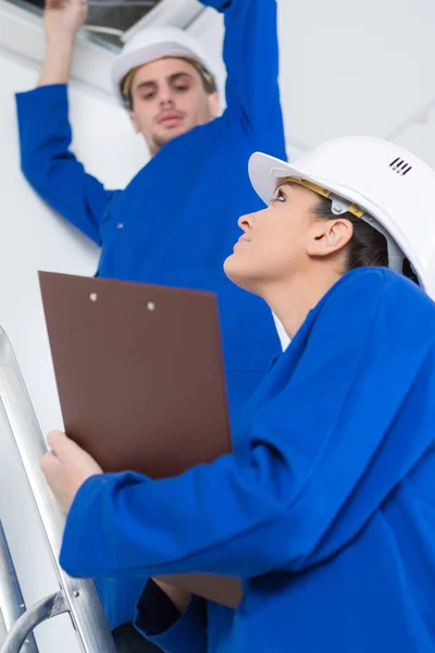 Young male electrician with female mentor — Stock Photo, Image