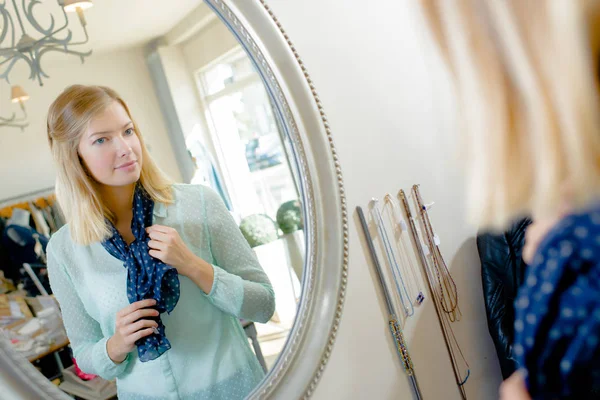 Dame essayant écharpe, regarder la réflexion dans le miroir — Photo