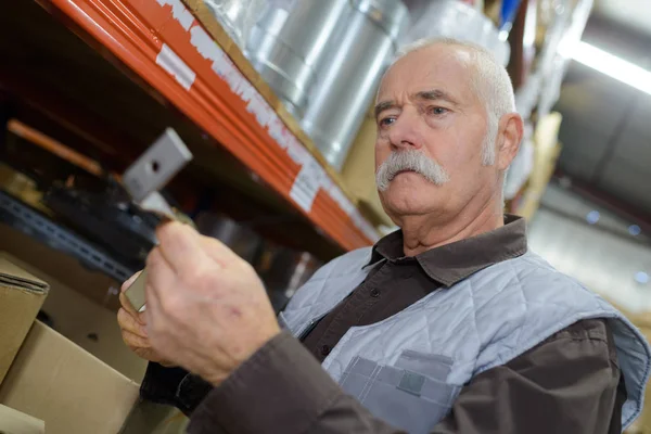 Man picking a part from the rack in the warehouse — Stock Photo, Image