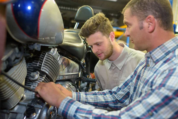 Dos hombres revisando una moto — Foto de Stock