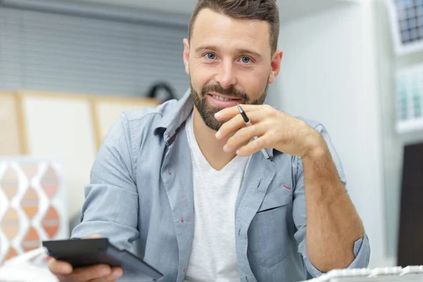 Zufriedene Geschäftsleute, die mit einem Taschenrechner arbeiten — Stockfoto