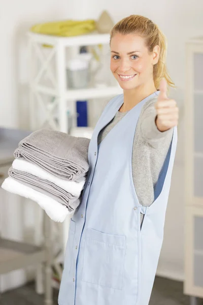 Женщина держит чистые сложенные полотенца — стоковое фото