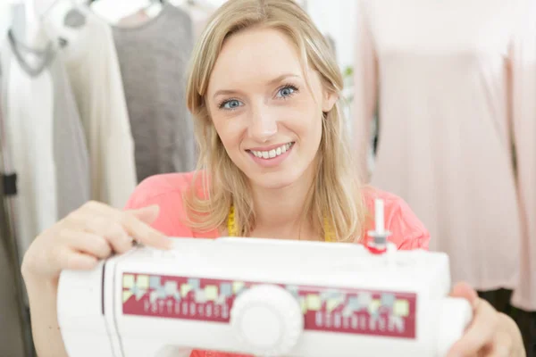 Hermoso sastre sonriente disfrutando del trabajo en la máquina de coser —  Fotos de Stock