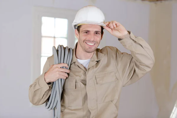 Eletricista com capacete e cabo — Fotografia de Stock