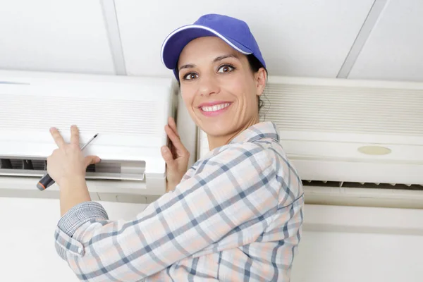 Woman using screwdriver on appliance — Stock Photo, Image