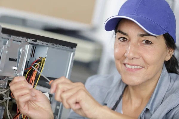 Dojrzała kobieta naprawić element komputera w centrum serwisowym — Zdjęcie stockowe
