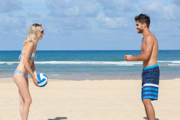 Пара, играющая в пляжный волейбол — стоковое фото
