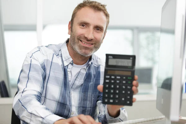 Un homme montrant une calculatrice — Photo
