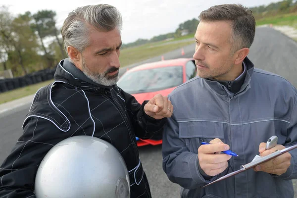 Meccanico con auto da corsa rossa — Foto Stock