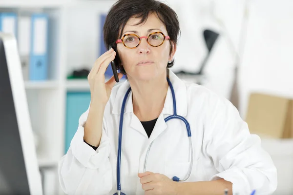 En läkare som håller i en smarttelefon — Stockfoto