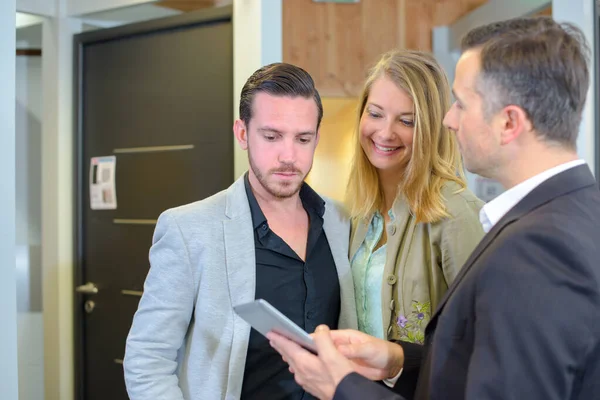 Salesman with young couple in home-improvement store — Stock Photo, Image