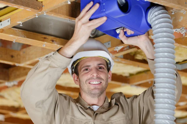 Thoughtful construction worker with pipes — Stock Photo, Image