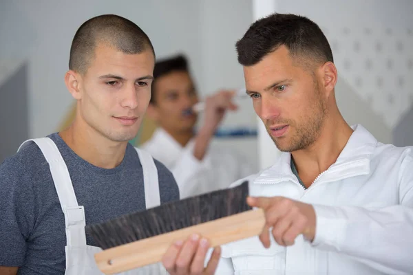Dos hombres inspeccionando un cepillo — Foto de Stock