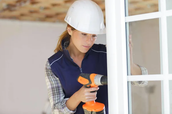 Vrouw schroeft bevestigingsschroeven handvat venster — Stockfoto