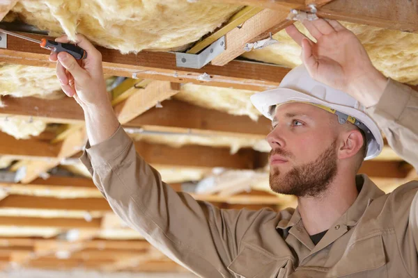 Carpenter driving screw nail into timber structure — Stock Photo, Image