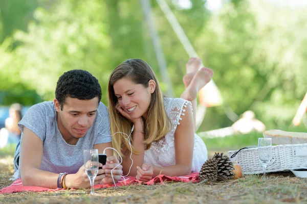 Junges kaukasisches Paar legt sich ins Gras — Stockfoto