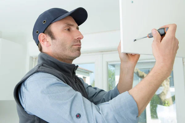 Handyman installing kitchen cupboard — ストック写真