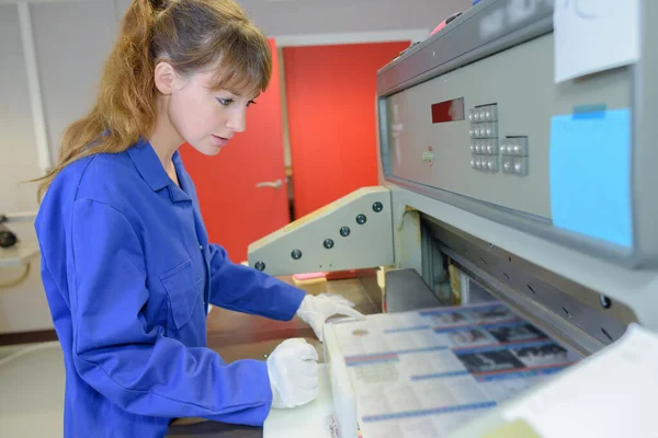 Jovem fêmea operando uma máquina — Fotografia de Stock