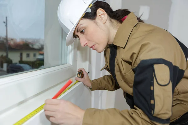 Femme mesure cadre de fenêtre avec ruban à mesurer — Photo