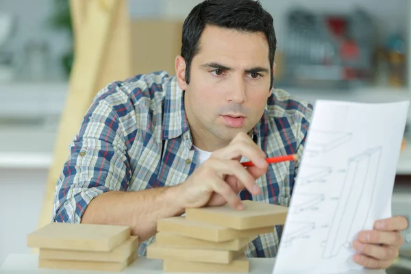 Man checking a furniture manual — Stock Photo, Image