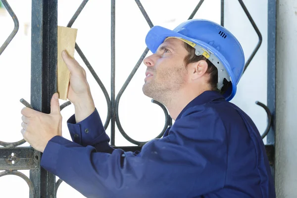 A man is sanding fence — Stockfoto