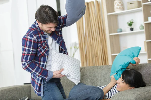 Coppia seduta sul divano di casa divertendosi — Foto Stock