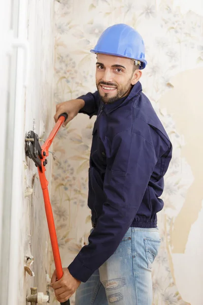 Um homem usando alicate dentro de casa — Fotografia de Stock