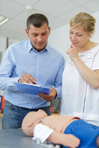 Donna in corso di primo soccorso utilizzando un manichino di dimensioni infantili — Foto Stock