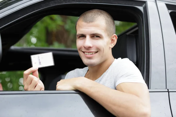Giovane uomo felice mostra la sua nuova patente di guida — Foto Stock