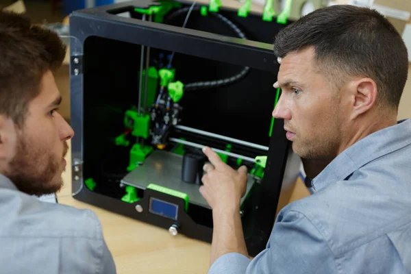 Опытный архитектор показывает ученику 3D принтер — стоковое фото