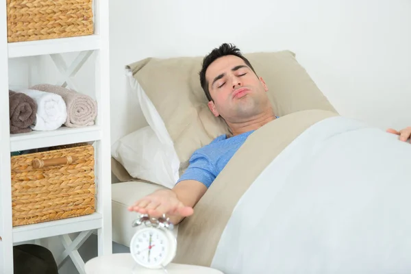 Despertar feliz de um homem feliz parar despertador — Fotografia de Stock