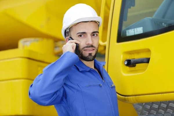 Man met behulp van telefoon stond naast de fabriek machines — Stockfoto