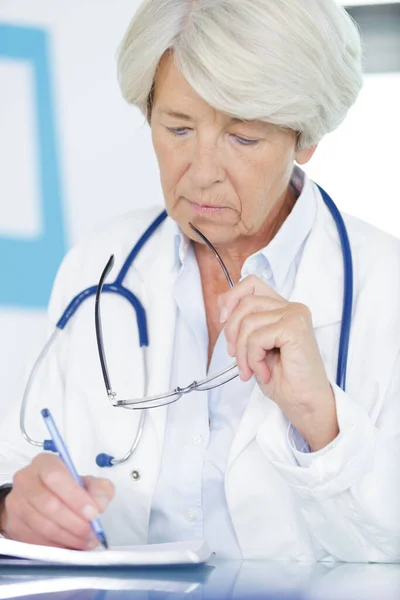 Retrato de médico feminino escrevendo na área de transferência — Fotografia de Stock