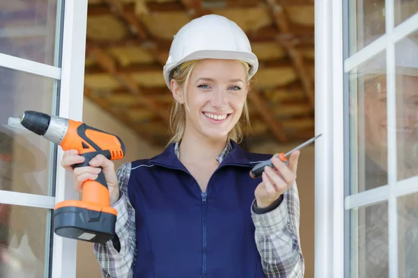 Porträt einer fröhlichen jungen Frau, die mit Werkzeugen arbeitet — Stockfoto