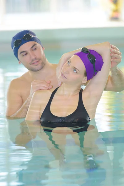 Pareja haciendo ejercicio en la piscina — Foto de Stock