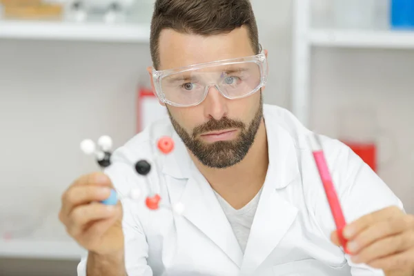 Trabalhador masculino segurando uma molécula 3d em laboratório — Fotografia de Stock