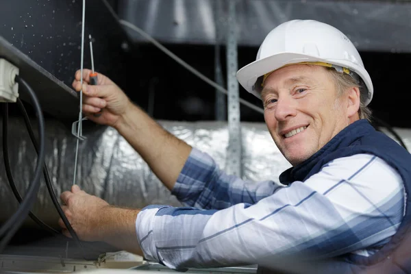 Un uomo sta lavorando su un soffitto — Foto Stock