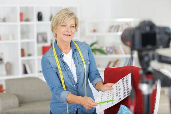 Glad senior kvinna väljer färg fläckar framför kameran — Stockfoto