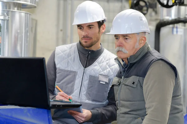 Trabajadores de supervisión de la destilería mirando el ordenador — Foto de Stock