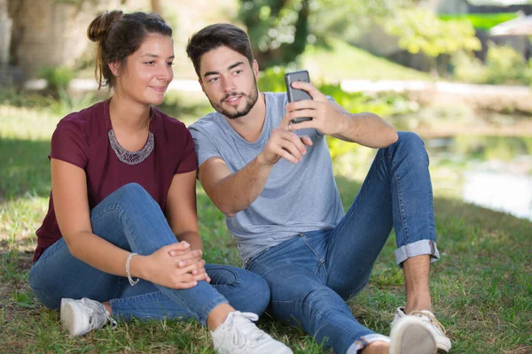 Beau couple prendre un selfie dans le parc — Photo