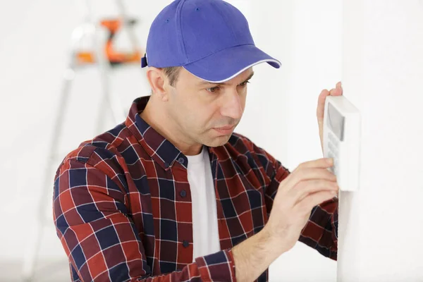 Man set the thermostat at house — Stock Photo, Image