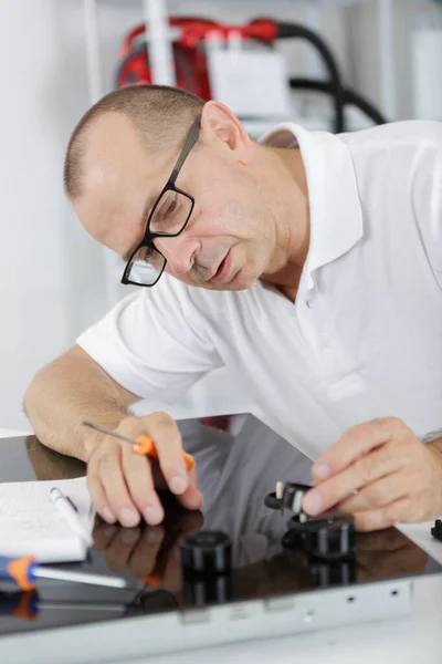 Ein Techniker schließt Küchenarmaturen an — Stockfoto