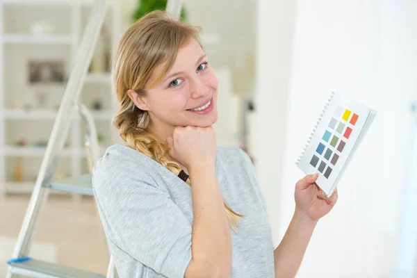 Νεαρή γυναίκα διαλέγει το χρώμα του τοίχου της — Φωτογραφία Αρχείου