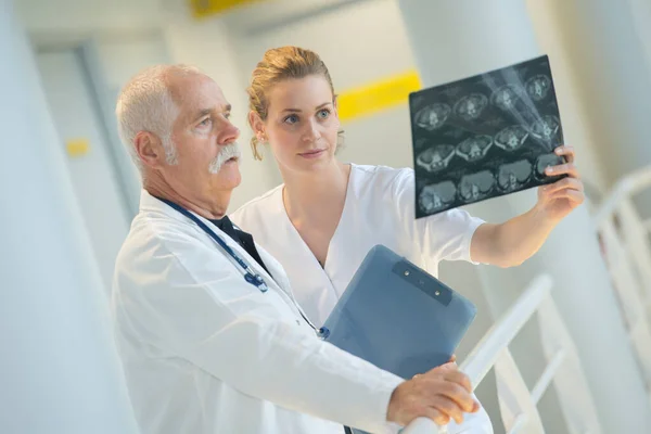 Médico y asistente mirando rayos X —  Fotos de Stock